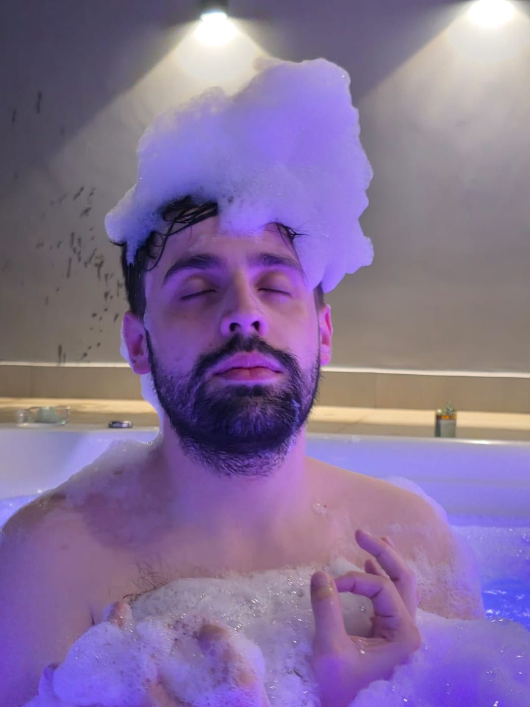 Ele na banheira cheia de espuma